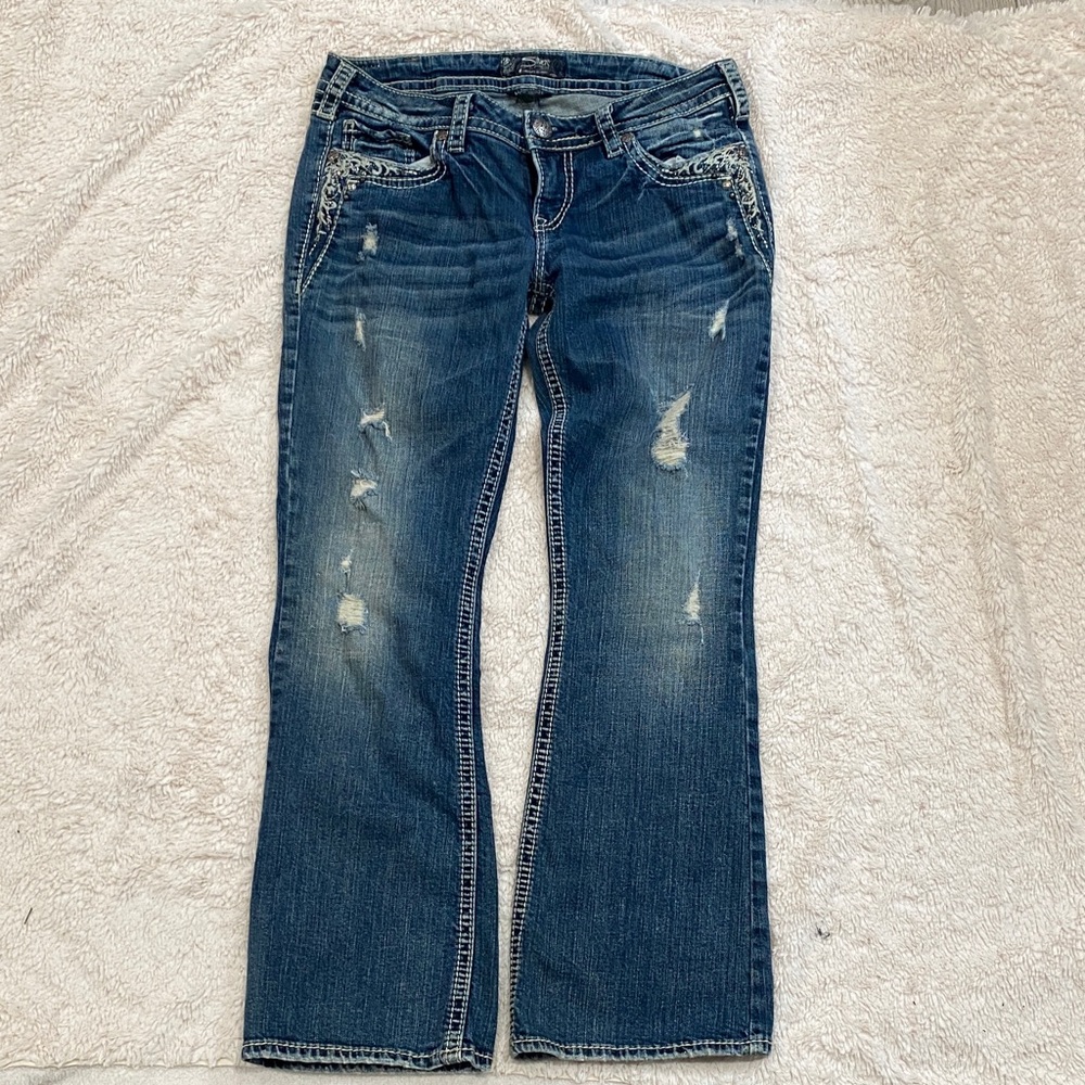 Silver Jeans Co. Tuesday low-rise slim bootcut jeans in a distressed blue denim